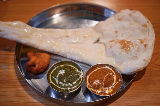 色鮮やかなインドカレーと大きなナン 色鮮やかなインドカレーと大きなナンの写真