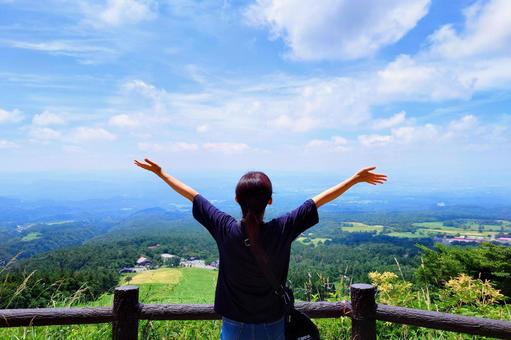 青空に両手を広げて深呼吸する女性の後ろ姿 空,女性,後ろ姿の写真素材