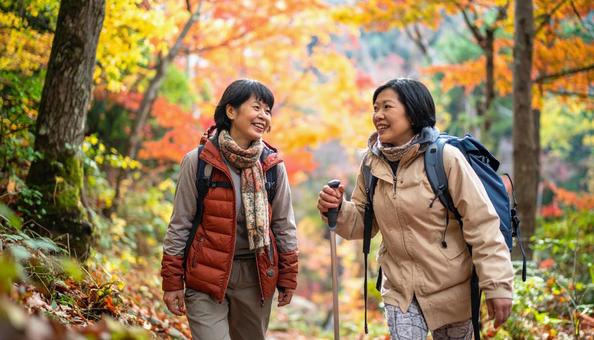 秋の山登りをするミドル女性二人の写真