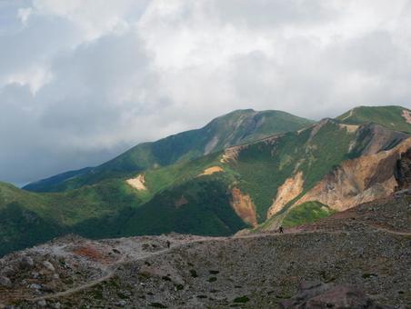 山頂から見る山肌と曇り空 山頂から見る山肌と曇り空の写真