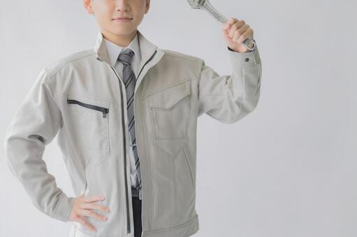 レンチを掲げる作業員の男性 作業員,レンチ,工具の写真素材