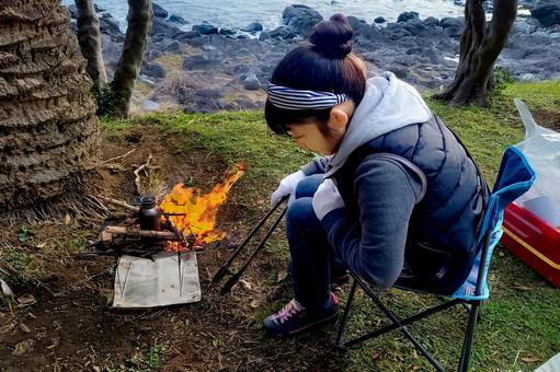 <素材>キャンプでお湯を沸かしている女性 <素材>キャンプでお湯を沸かしている女性 女性,人物,風景の写真素材