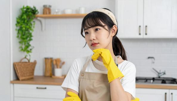 悩むエプロン姿の若い日本人女性 悩むエプロン姿の若い日本人女性の写真