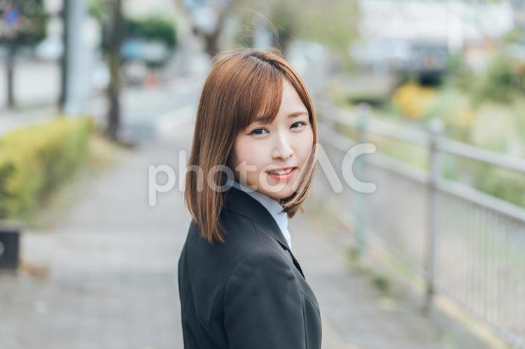 振り返って微笑むスーツの女性 ビジネス,スーツ,通話の写真素材
