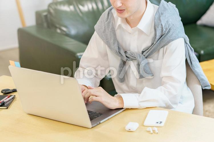 カジュアルな服装でノートPCを使う男性  男性,フリーアドレス,ビジネスの写真素材