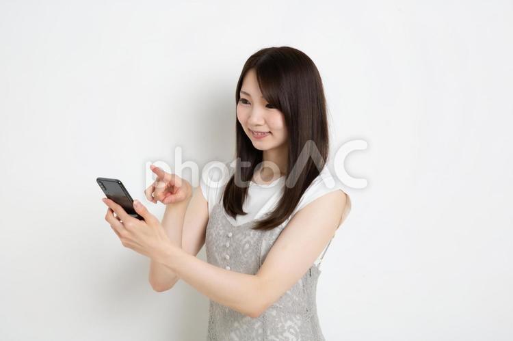 スマートフォンで検索をしている若い女性 女,女性,女の子の写真素材