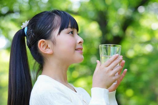公園でグラスの水を飲む女の子 子ども,女の子,小学生の写真素材