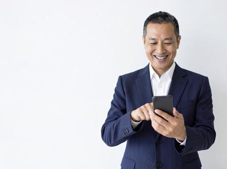 スマホ 50代 笑顔 嬉しい知らせ スマホ 50代 笑顔 嬉しい知らせ の写真