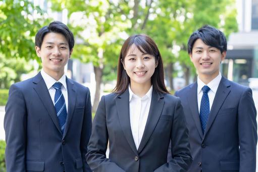 屋外で笑顔を見せる若手ビジネスパーソンの写真