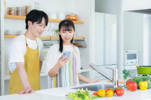 キッチンで料理を作る若い夫婦 キッチンで料理を作る若い夫婦 夫婦,料理,キッチンの写真素材