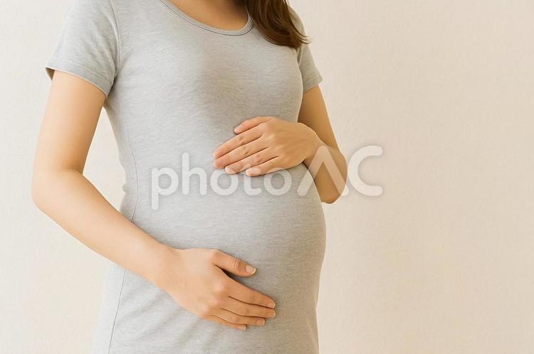 立った状態でお腹に手を添える妊婦の上半身 妊婦,お腹に手,マタニティの写真素材