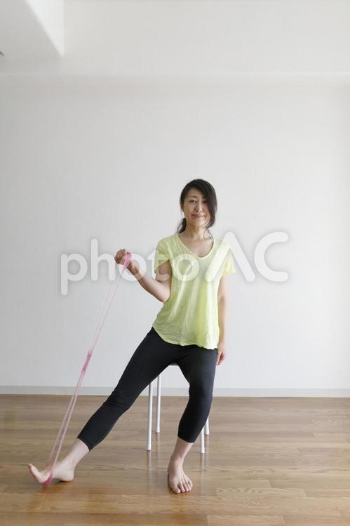 ゴムチューブを使ってストレッチ運動をする女性 女性,人物,日本人の写真素材