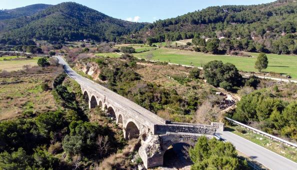 山間を渡る石造アーチ橋のある風景の写真