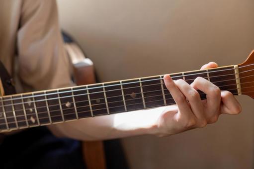 夕陽で浮かび上がるギターを弾く手 ギター,アコースティックギター,楽器の写真素材