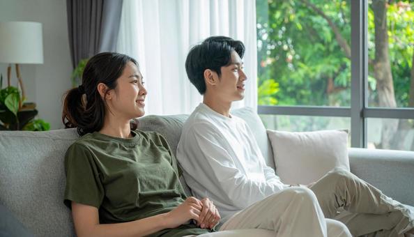 リビングでくつろぐ若いカップルの横顔 リビングでくつろぐ若いカップルの横顔の写真