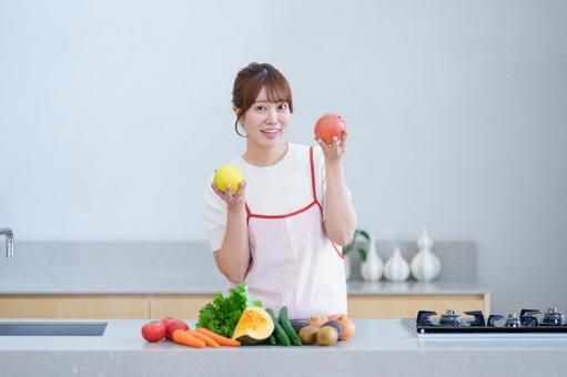 両手にリンゴを持つ笑顔の女性の写真