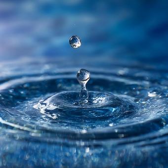 青い水面に広がる水滴の波紋 青い水面に広がる水滴の波紋の写真