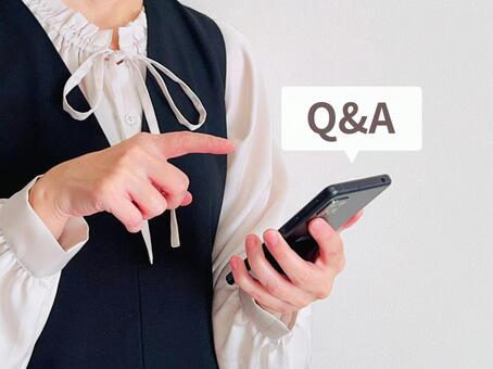 スマホのサイトからQ&Aを確認する女性 お問い合わせ,q&a,相談の写真素材