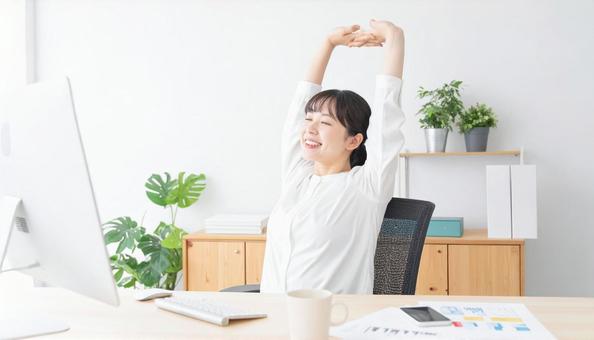 資料作成完了後に背伸びするビジネスマンの写真