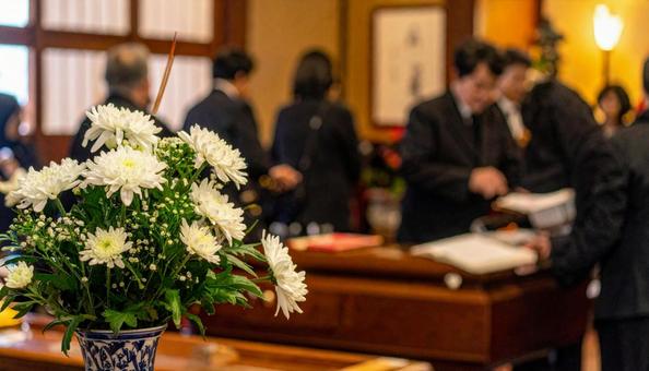 葬儀場の白い花と葬式の弔問客 葬儀場の白い花と葬式の弔問客の写真