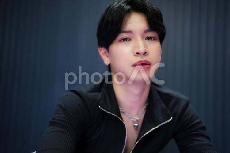 カメラ目線のネックレスをした黒い服の男性 男性,アイドル,真顔の写真素材