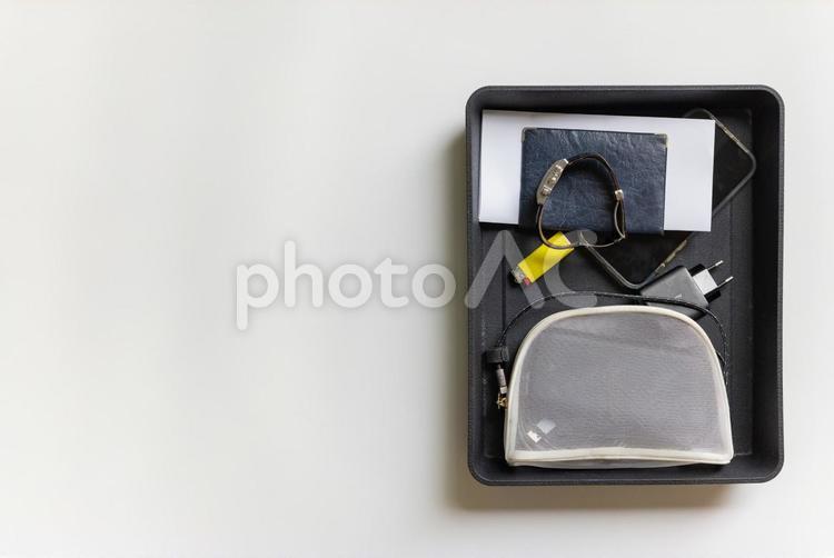 右寄りの黒いトレイにメッシュポーチと携帯と腕時計 貴重品,ゼロエミッション,トレイの写真素材
