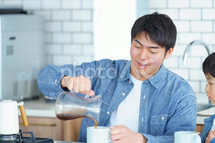 笑顔でコーヒーを注ぐ男性 親子,男の子,男性の写真素材