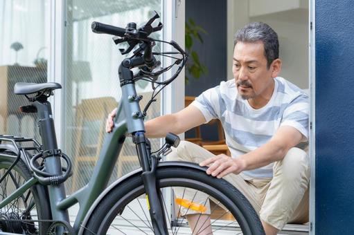 電動自転車をメンテナンスをするミドル男性 電動自転車,男性,ミドルの写真素材