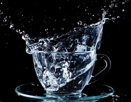 透明のカップから勢いよくあふれる水2 透明のカップから勢いよくあふれる水2の写真