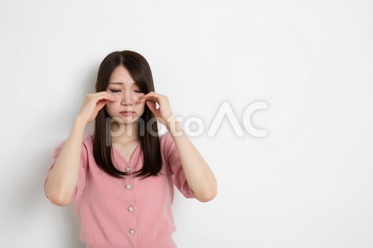 目を伏せて悲しんでいる若い女性（コピースペース） 女性,女,悲しいの写真素材