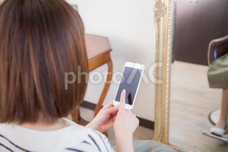 美容室でスマホを指さす女性 女性,スマホ,美容室の写真素材