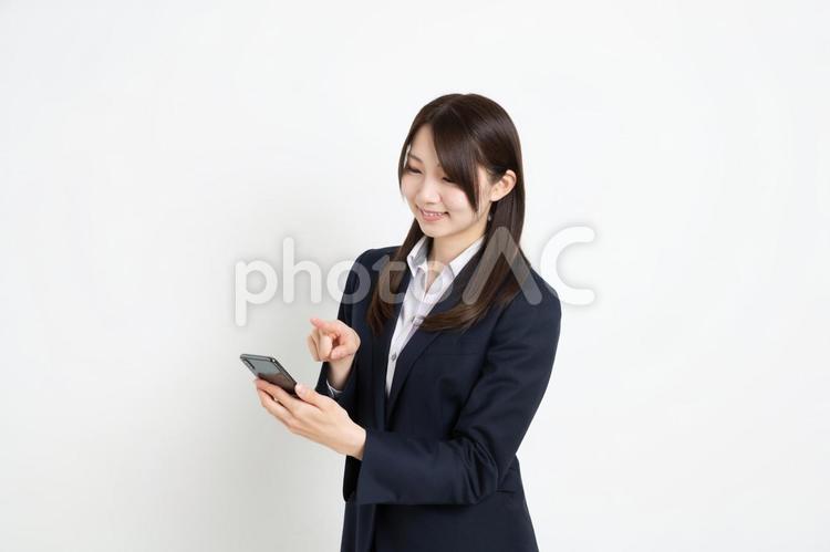 スマートフォンで検索をしているビジネスウーマン ビジネス,女性,笑顔の写真素材