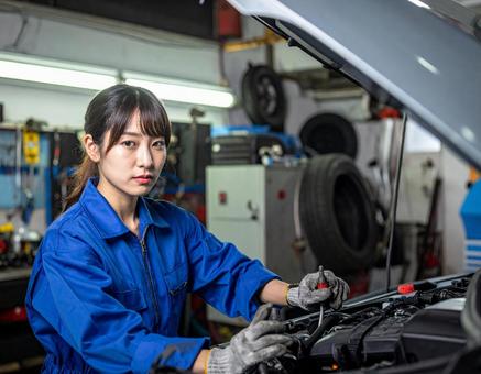 自動車工場でエンジン整備する女性スタッフの写真