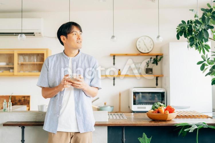 家でスマホを使う男性（アプリ） スマホ,男性,スマートフォンの写真素材