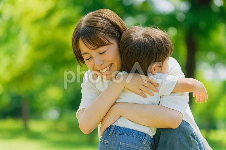 自然の中で男の子を抱く笑顔の母親 親子,母親,ママの写真素材