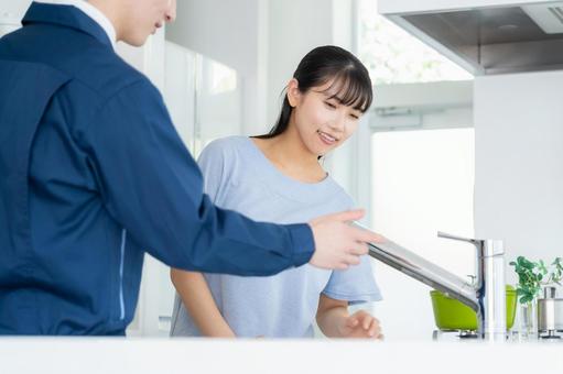 キッチンで女性に説明をする不動産業者 キッチンで女性に説明をする不動産業者の写真