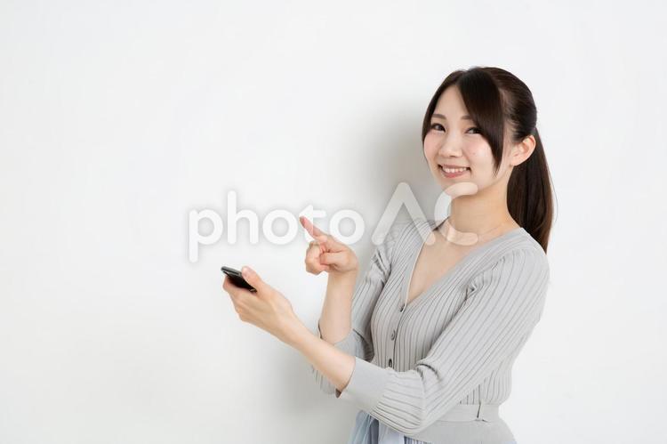 スマートフォンで検索をしているポニーテールの女性（コピースペース） 女,女性,日本人の写真素材