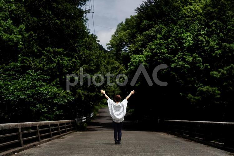 ＜素材＞新緑の初夏の山道を散歩する女性 女性,橋,道路の写真素材