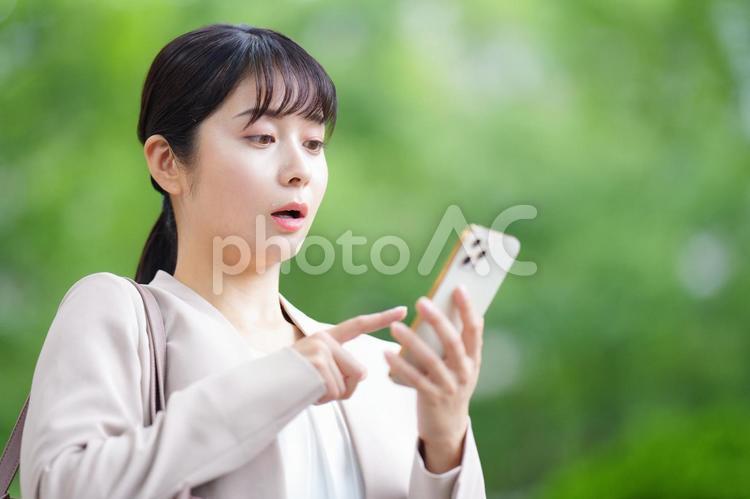 携帯を指さして驚く女性 女性,人物,大学生の写真素材