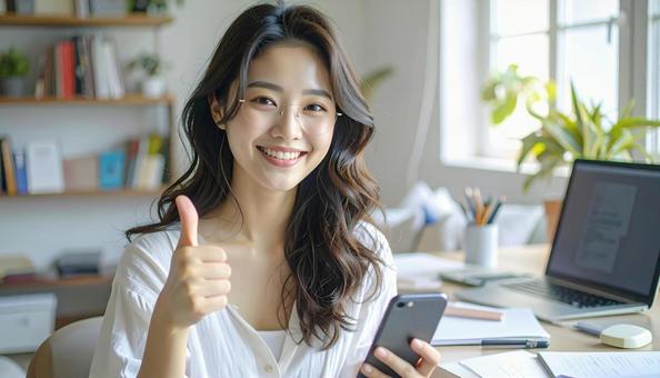 家計がうまくいきスマホ片手に微笑む女性 家計がうまくいきスマホ片手に微笑む女性の写真