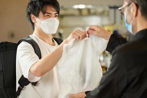 Asian man receiving a meal to deliver Asian man receiving a meal to deliver