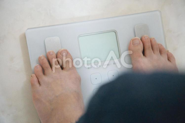 恐る恐る体重計に足を載せる女性の足元 体重,体重測定,ダイエット中の写真素材