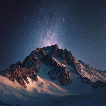 夜空に広がる天の川と雄大な雪山 夜空に広がる天の川と雄大な雪山の写真