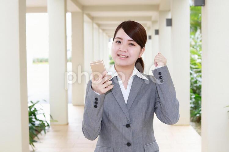 スマートフォンを持つ笑顔の女性 女性,ビジネスウーマン,笑顔の写真素材