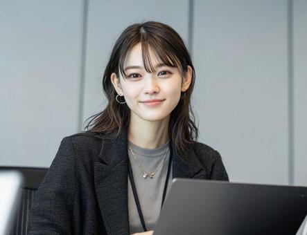 オフィスでパソコンを使う若い女性 オフィスでパソコンを使う若い女性の写真