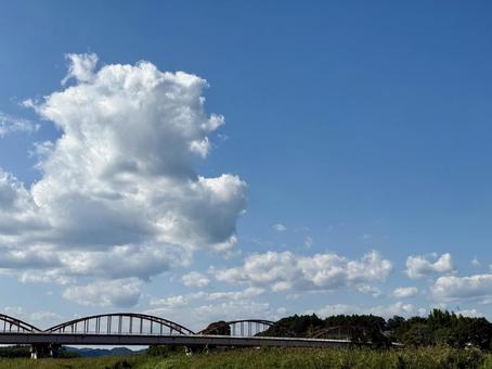 夏の空に浮かぶ雄大な雲と古い赤い橋 夏の空に浮かぶ雄大な雲と古い赤い橋 青空,雲,積雲の写真素材