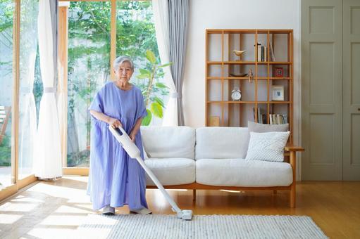 真顔で白い掃除機を持つワンピースの女性 女性,掃除,掃除機の写真素材