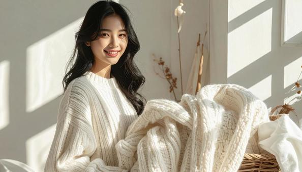 ニットの片づけをする女性 ニットの片づけをする女性の写真