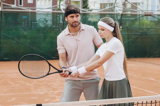 屋外コートでのテニスレッスン風景 男女,外国人,テニスの写真素材