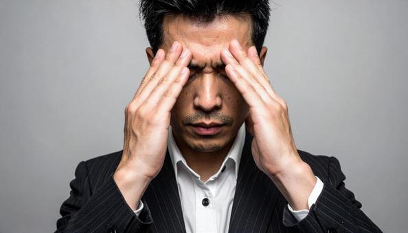 目を手で押さえて苦しむ日本人ビジネスマン 目を手で押さえて苦しむ日本人ビジネスマンの写真